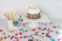 balloons mini and celebration hat on cake stand and cutie container