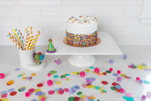 balloons mini and celebration hat on cake stand and cutie container