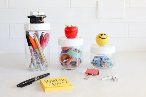 graduation hat mini on a large container, apple on medium container and happy face on small container
