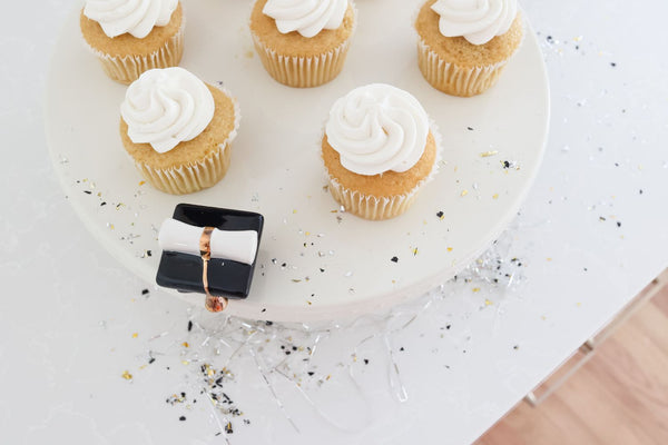 graduation hat on cake stand with cupcakes