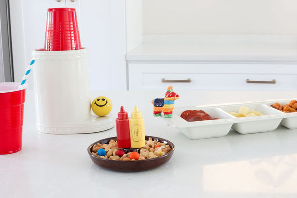 ketchup and mustard mini, happy face mini and pinata mini on a divided dish, dainty dish, utensil crock and solo cups