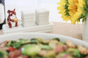squirrel holding a gold acorn mini on salt and pepper shakers with salad and bright yellow sunflowers