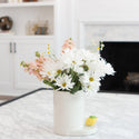 lemon squeeze mini on a round utensil crock filled with white daisies