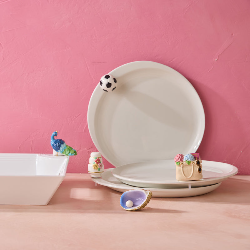White ceramic plates with decorative elements on a pink background