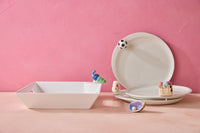 White ceramic plates with decorative elements on a pink background