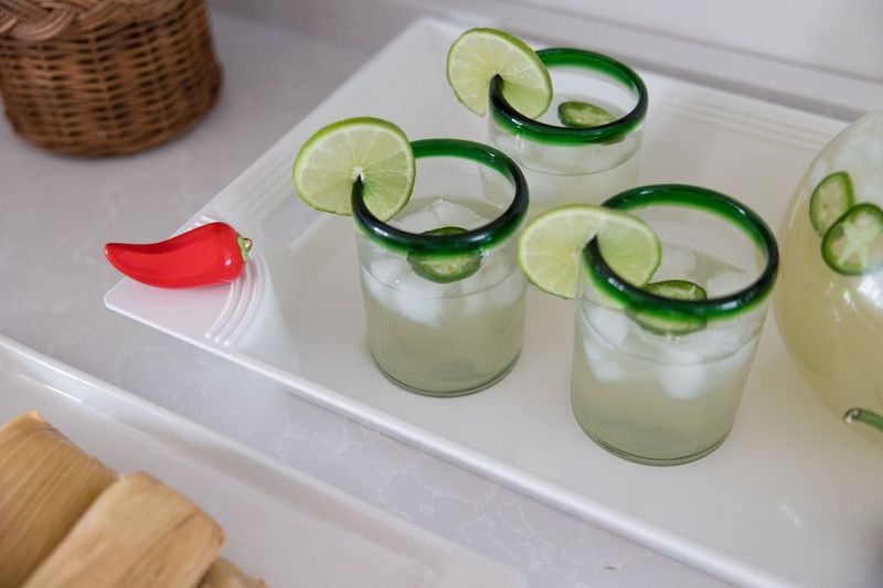 white rectangle tray topped with a hot pepper mini. the tray is filled with glasses of margaritas.