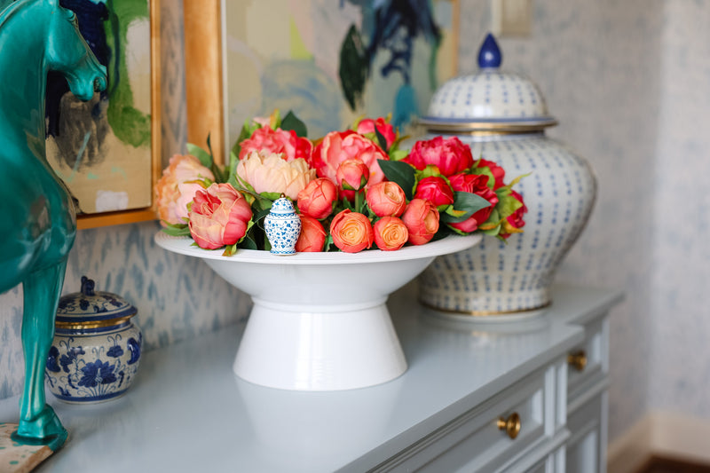 Decorative table with flowers, vases, and a ginger jar mini.