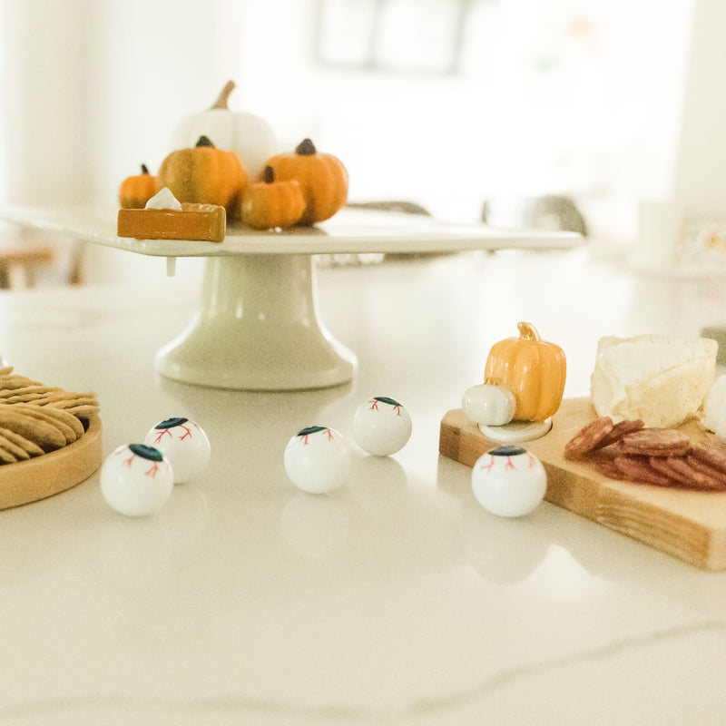 pumpkin pie mini on cake stand and haunted house mini on round wood board and pumpkin mini on wood board