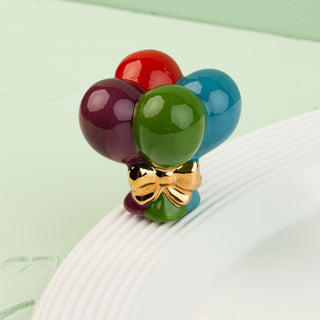 Colorful balloon-shaped mini with a gold bow on a white surface.
