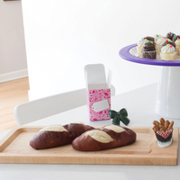 This image features a handcrafted maple bread board designed by J.K. Adams with a bread basket mini, a round platter with black cat mini, gumball mini on a round platter sitting on a high riser.