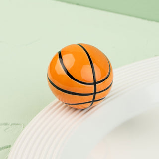 basketball mini on a white surface with a green background