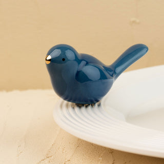 Blue ceramic bird mini on a beige background