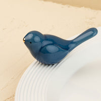 Blue ceramic bird mini on a beige background
