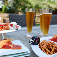 Outdoor setting with pizza, beer, and snacks on a table with platters and minis