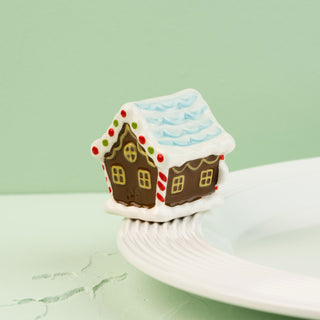 Gingerbread house mini  on a white plate with a green background