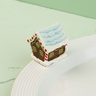 Gingerbread house mini  on a white plate with a green background