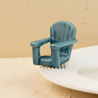 Blue Adirondack chair mini on a white plate with sand background