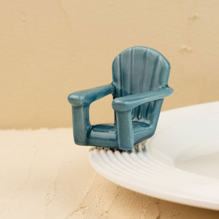 Blue Adirondack chair mini on a white plate with sand background