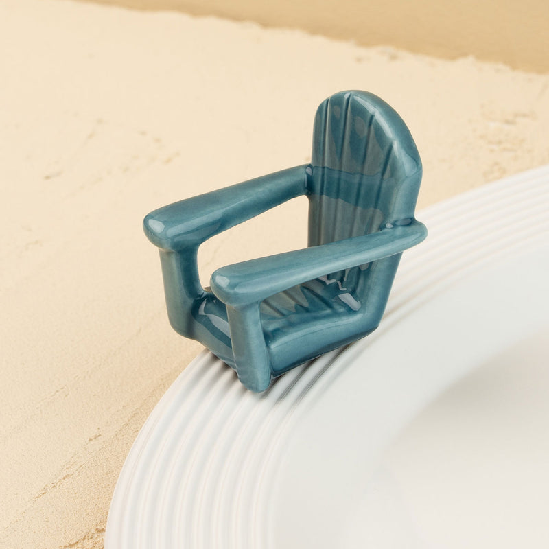 Blue Adirondack chair mini on a white plate with sand background