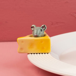 Small gray mouse on a yellow wedge of cheese mini with a pink background