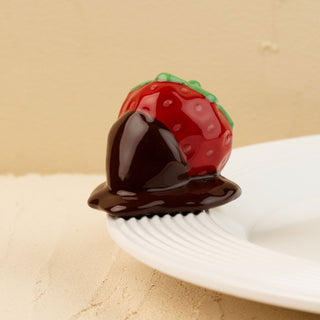 Strawberry-shaped mini covered in chocolate on a beige background
