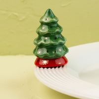 Decorative green Christmas tree mini with star patterns on a white surface and light green background