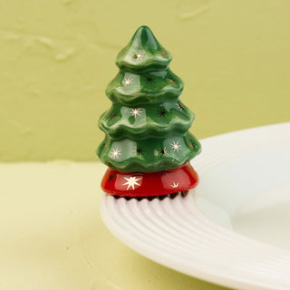 Decorative green Christmas tree mini with star patterns on a white surface and light green background