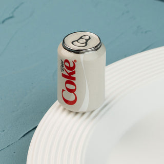 Coca-Cola can-shaped bottle mini on a textured surface