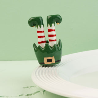 elf legs with striped socks mini on a green background