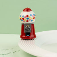 mini gumball machine with colorful polka dots on a light green background