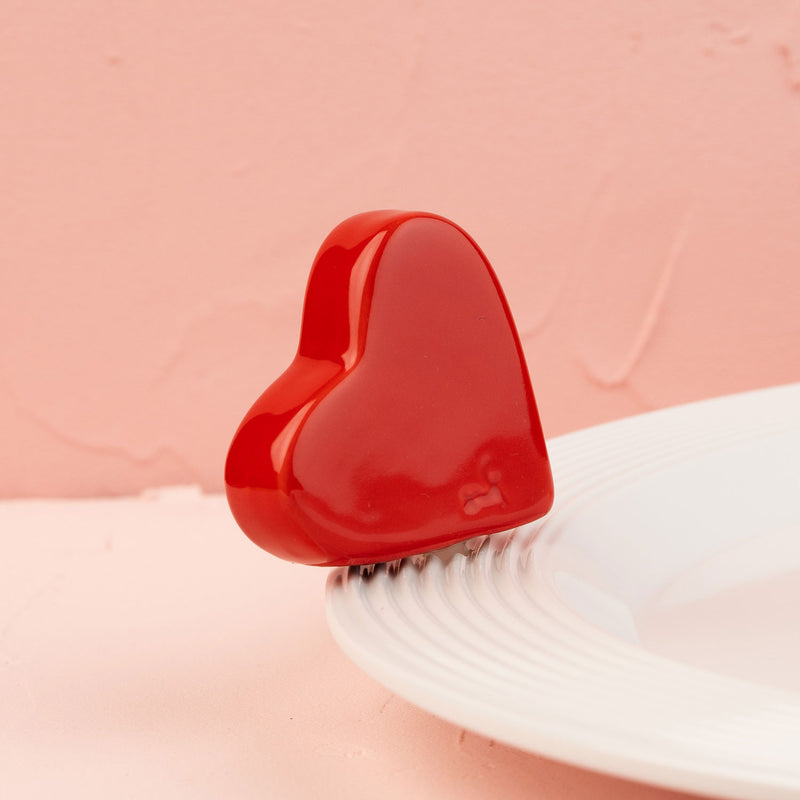 Red heart-shaped mini on a white platter with a pink background