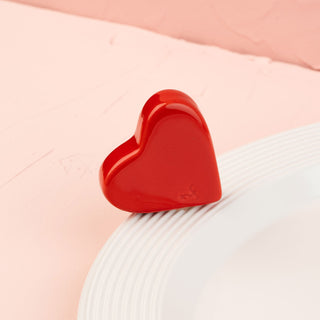 Red heart-shaped mini on a white platter with a pink background