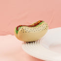 Hot dog mini on a white plate with a pink background