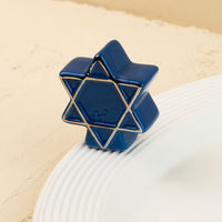 Blue star of david object on a beige surface