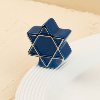 Blue star of david object on a beige surface