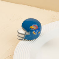 A small, blue University of Kansas football helmet with a Jayhawk logo on it.