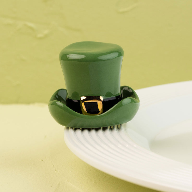 Green top hat on a white plate with a green background