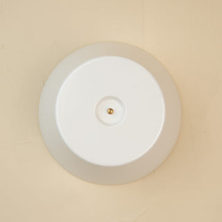 A white round melamine riser with a central screw hole, designed to hold a platter. 
