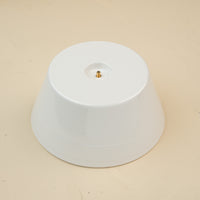 A white round melamine riser with a central screw hole, designed to hold a platter. 