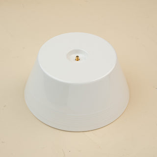 A white round melamine riser with a central screw hole, designed to hold a platter. 