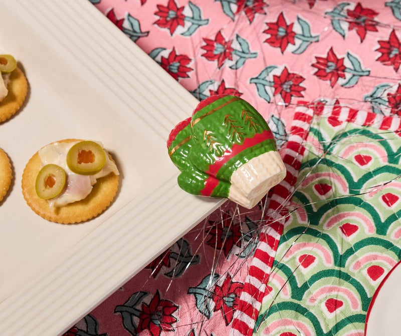 Decorative Christmas-themed mitten mini on a pink floral fabric background
