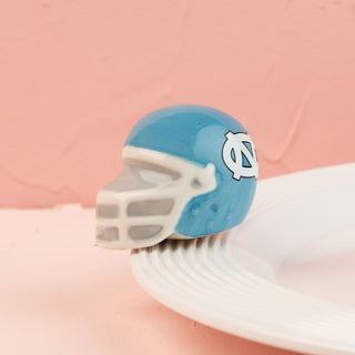 Blue and white north carolina football helmet mini on a pink background