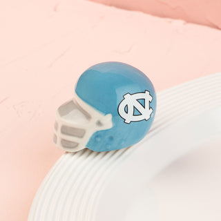 Blue and white north carolina football helmet mini on a pink background