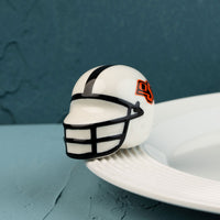 A small, decorative Oklahoma State University helmet mini with a logo on the side.