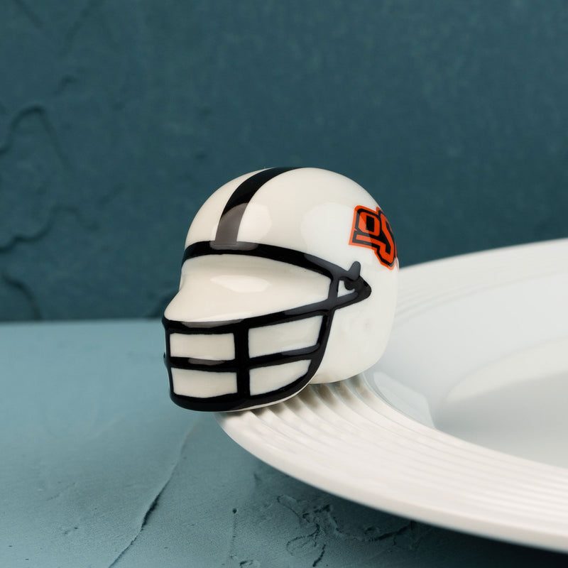 A small, decorative Oklahoma State University helmet mini with a logo on the side.