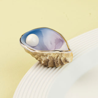 Ring with a blue stone and pearl on a beige background