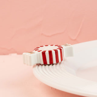 Red and white striped peppermint mini on a light pink background