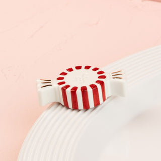Red and white striped peppermint mini on a light pink background