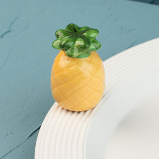 Pineapple-shaped mini on a white surface with a blue background