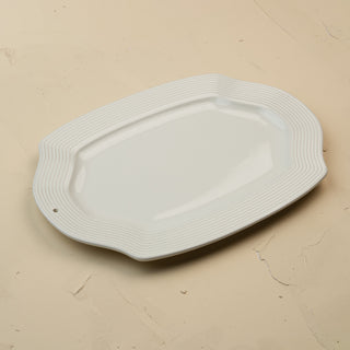 White ceramic platter with wavy edge on a beige background